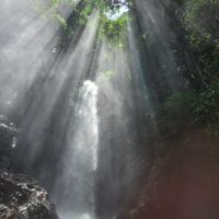 Swimmer under waterfall on Valle de las Cascadas trek