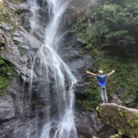 Traveler photographing waterfall on tour