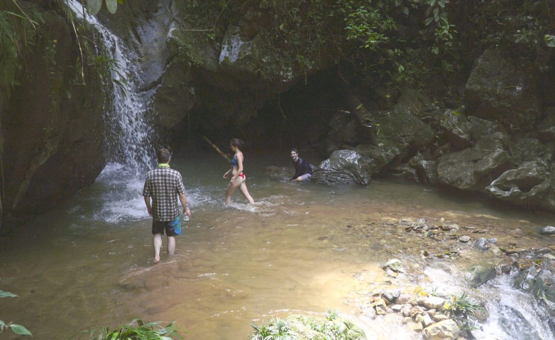 group swimming in waterfall