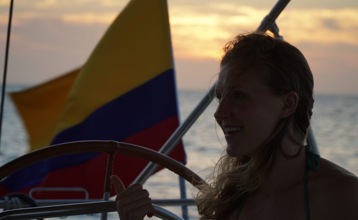 girl on sailboat with colombian flag in background